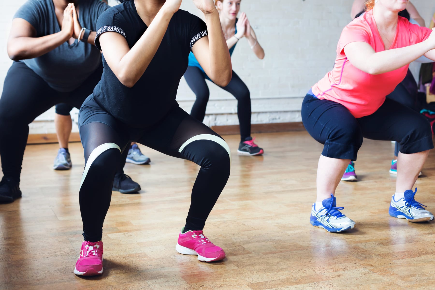 Group of women doing squats together in a fitness class